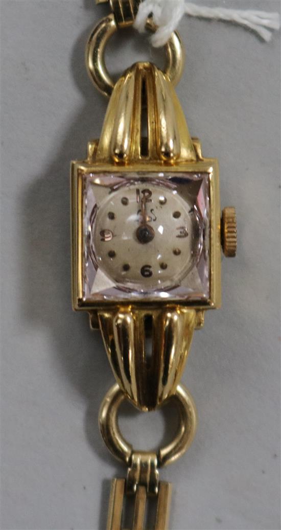 A ladys 18ct gold wrist watch on a rolled gold bracelet.